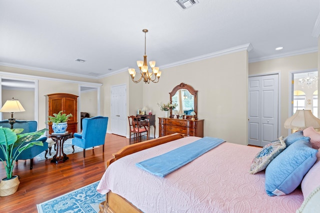 bedroom featuring a closet, ornamental molding, a chandelier, and hardwood / wood-style flooring