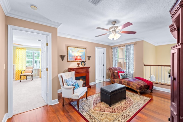 bedroom with ceiling fan, hardwood / wood-style floors, crown molding, and a textured ceiling