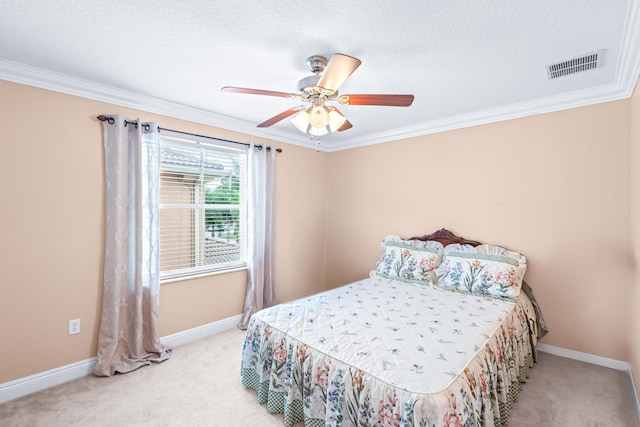 bedroom featuring a textured ceiling, light colored carpet, ceiling fan, and ornamental molding