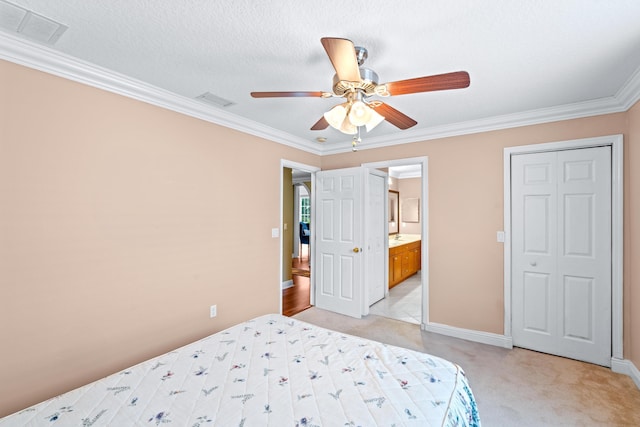 carpeted bedroom with connected bathroom, ceiling fan, crown molding, a textured ceiling, and a closet