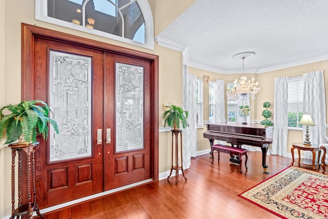 foyer entrance featuring a textured ceiling, hardwood / wood-style floors, french doors, and an inviting chandelier