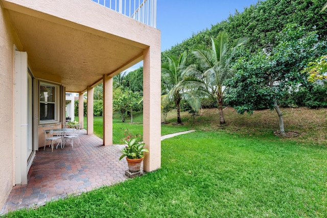 view of yard with a balcony and a patio