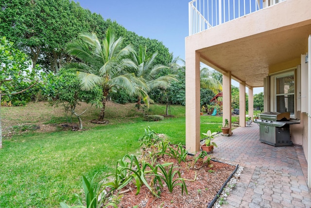 view of yard featuring a playground, a patio, and a balcony