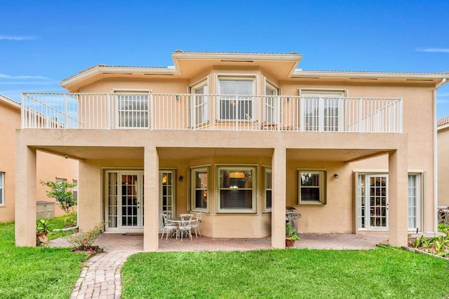 back of house with a yard and a patio