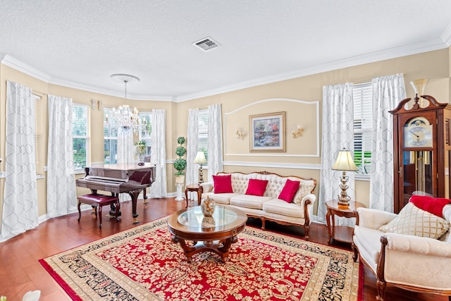 living room with a chandelier, a healthy amount of sunlight, wood-type flooring, and a textured ceiling