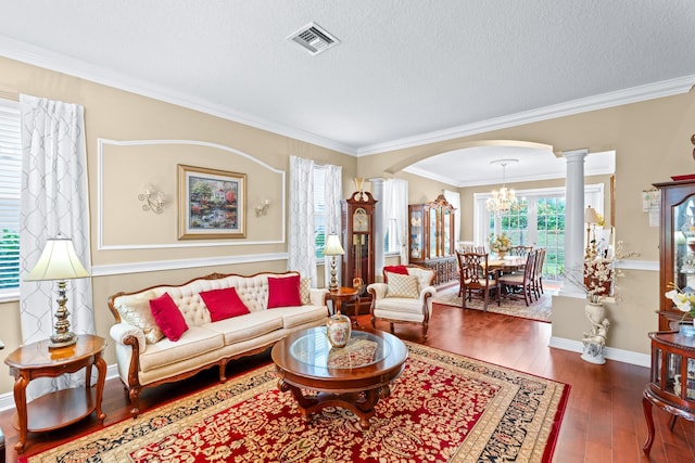 living room with ornate columns, ornamental molding, a textured ceiling, a chandelier, and dark hardwood / wood-style floors