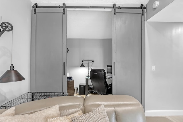 bedroom with a barn door and hardwood / wood-style flooring