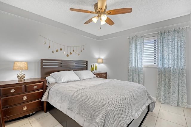 bedroom featuring ceiling fan, light tile patterned floors, and a textured ceiling