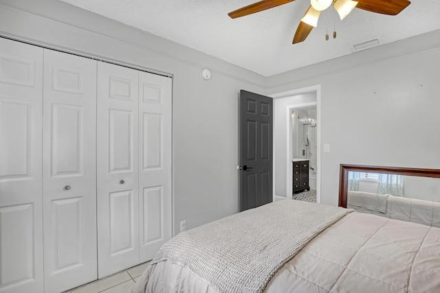 bedroom featuring light tile patterned floors, a textured ceiling, a closet, and ceiling fan