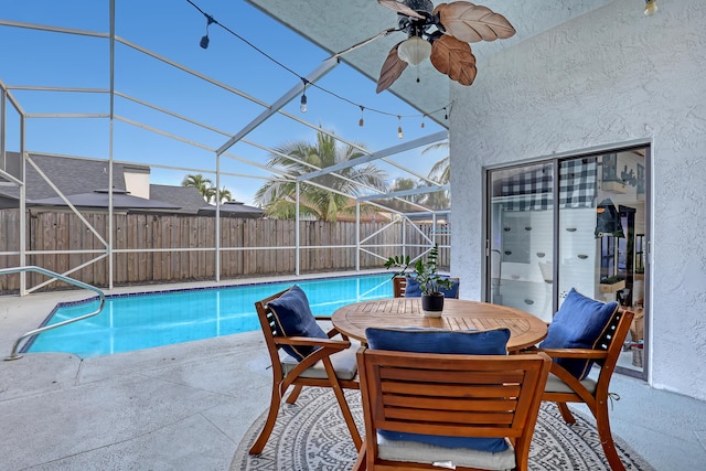 view of pool with ceiling fan, a lanai, and a patio