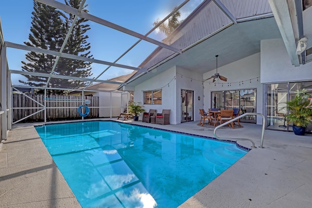 view of pool featuring a storage unit, glass enclosure, ceiling fan, and a patio area