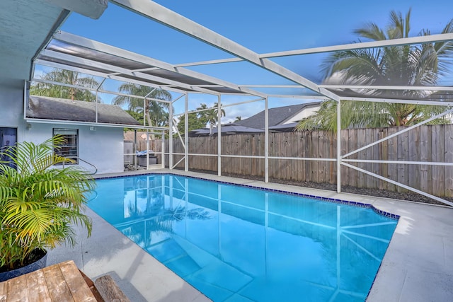 view of pool with glass enclosure and a patio