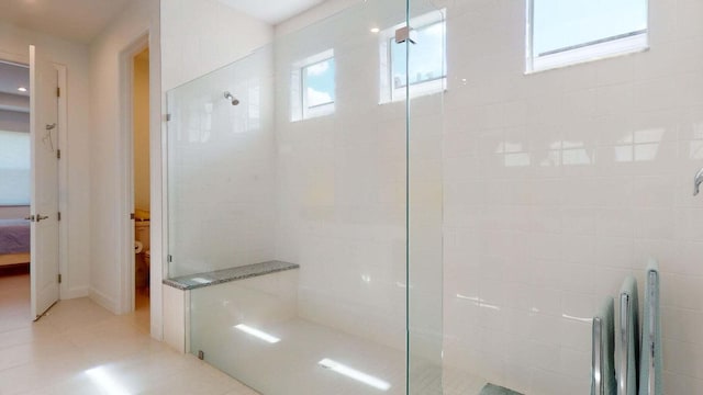 bathroom featuring tile patterned floors and a tile shower