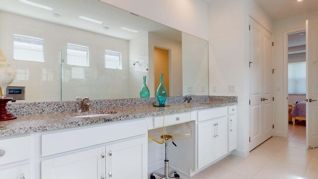 bathroom featuring tile patterned floors, a wealth of natural light, vanity, and tiled shower