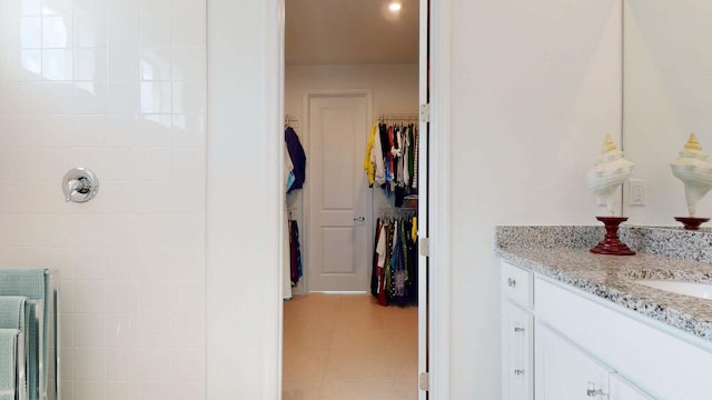 bathroom with tile patterned floors, vanity, and walk in shower