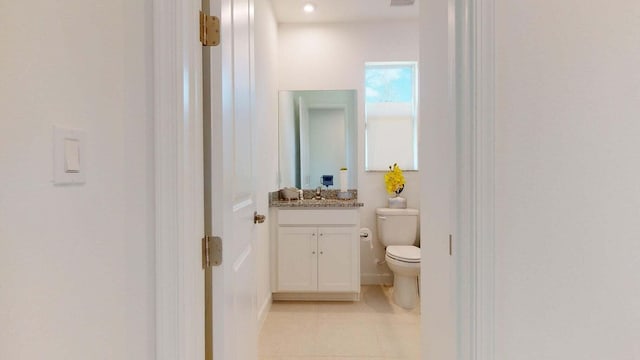 bathroom featuring tile patterned flooring, vanity, and toilet