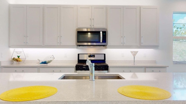 kitchen with sink, white cabinets, and appliances with stainless steel finishes