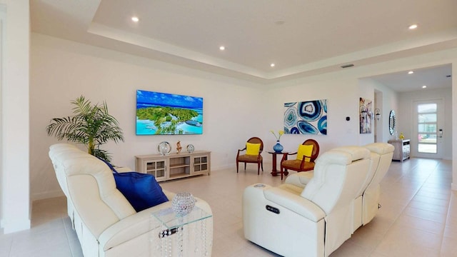 living room with light tile patterned floors and a raised ceiling