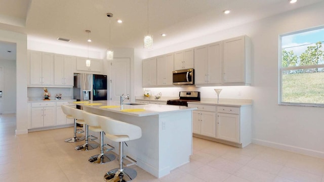 kitchen with plenty of natural light, white cabinetry, sink, and appliances with stainless steel finishes