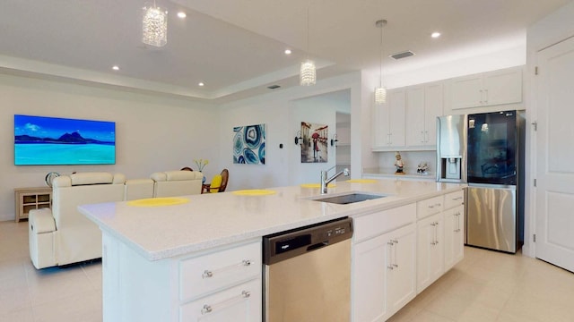 kitchen featuring white cabinetry, sink, pendant lighting, a kitchen island with sink, and appliances with stainless steel finishes