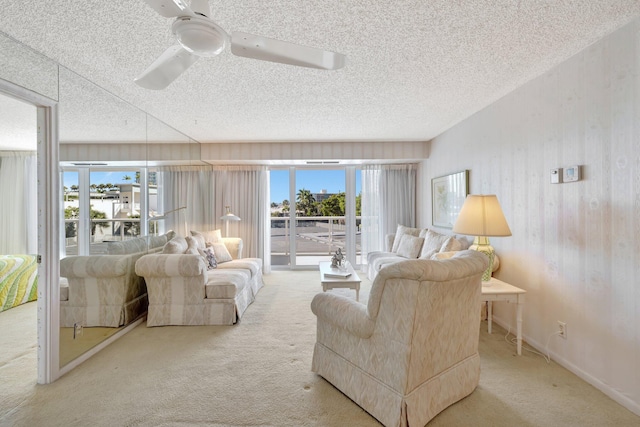 carpeted living room with ceiling fan and a textured ceiling