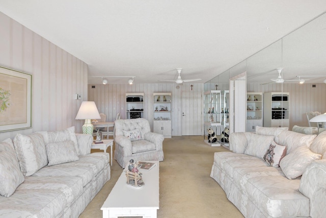 living room featuring a textured ceiling, light colored carpet, and ceiling fan