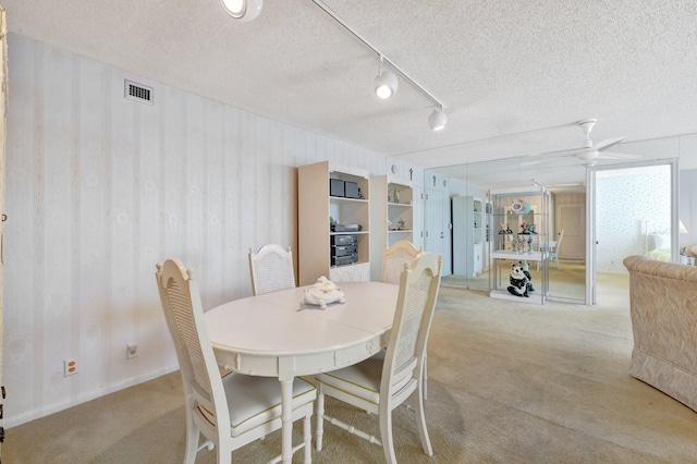 carpeted dining space featuring ceiling fan and a textured ceiling