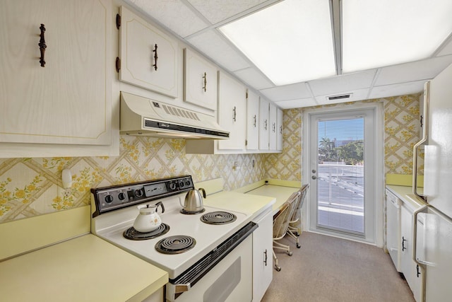 kitchen featuring light carpet, a drop ceiling, white cabinets, and white appliances