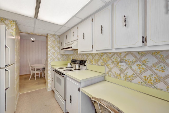 kitchen featuring a paneled ceiling, white cabinets, white appliances, and light carpet