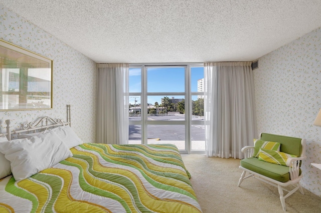 carpeted bedroom with access to exterior and a textured ceiling