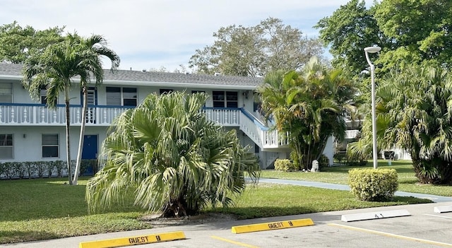 view of building exterior with stairs and uncovered parking