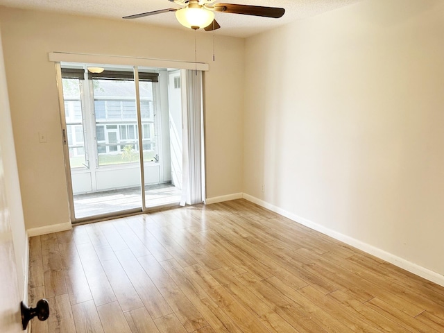 unfurnished room featuring ceiling fan, light wood-type flooring, and a textured ceiling