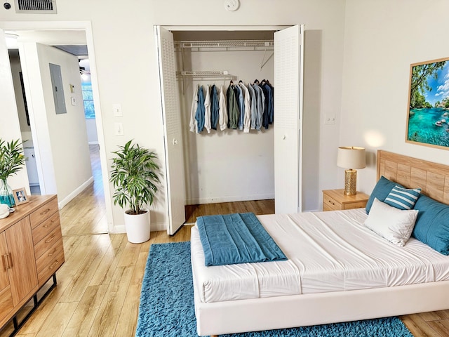 bedroom with light hardwood / wood-style floors and a closet