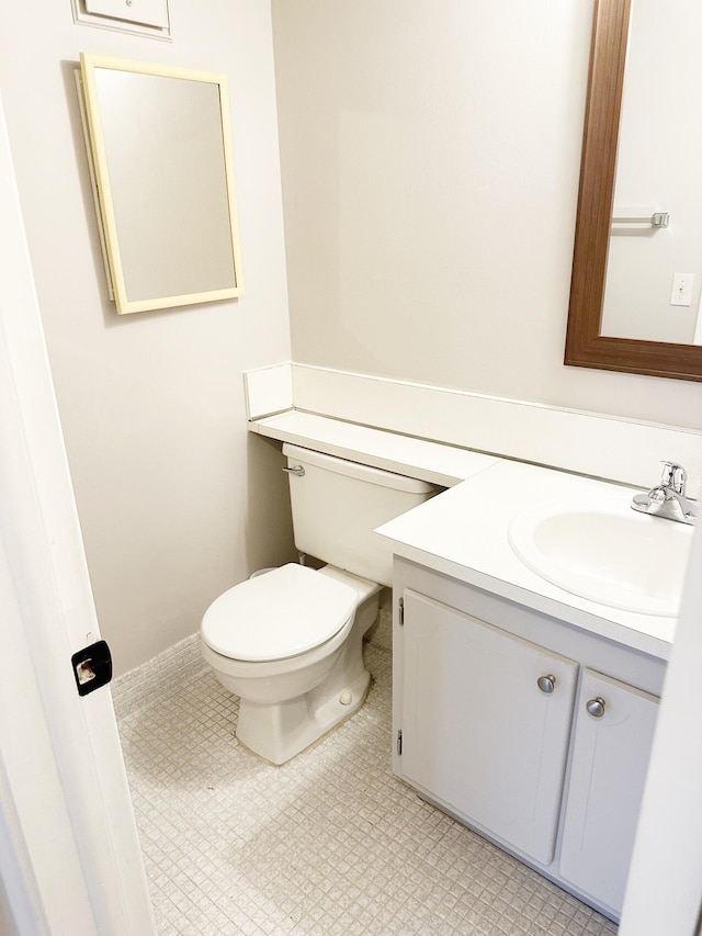 bathroom featuring tile patterned floors, vanity, and toilet