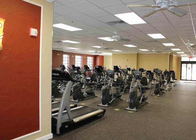 gym with a paneled ceiling and ceiling fan