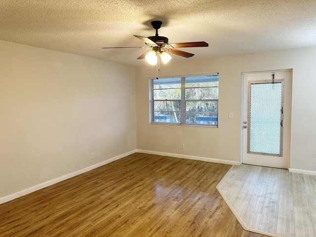 foyer entrance with ceiling fan, light wood-type flooring, and a textured ceiling