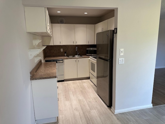 kitchen featuring white cabinetry, sink, light hardwood / wood-style floors, and appliances with stainless steel finishes