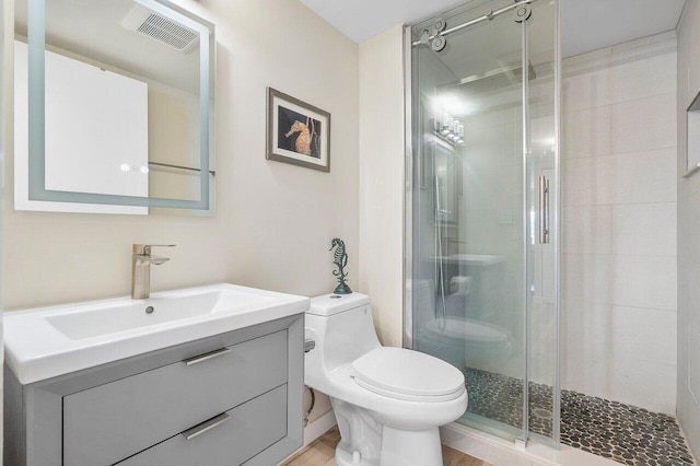 bathroom with hardwood / wood-style floors, vanity, toilet, and a shower with door