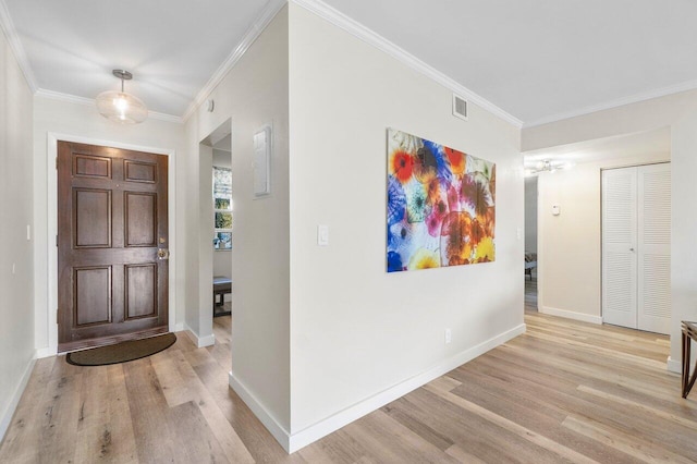 foyer entrance with light hardwood / wood-style flooring and crown molding