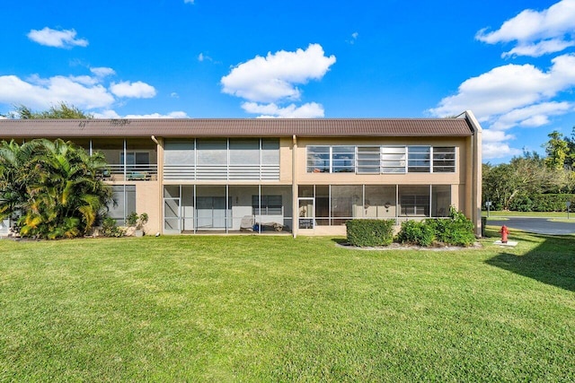 rear view of property featuring a lawn