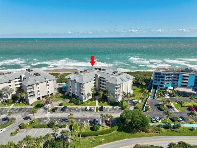 birds eye view of property featuring a water view and a beach view