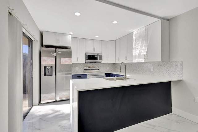 kitchen with kitchen peninsula, decorative backsplash, sink, and stainless steel appliances