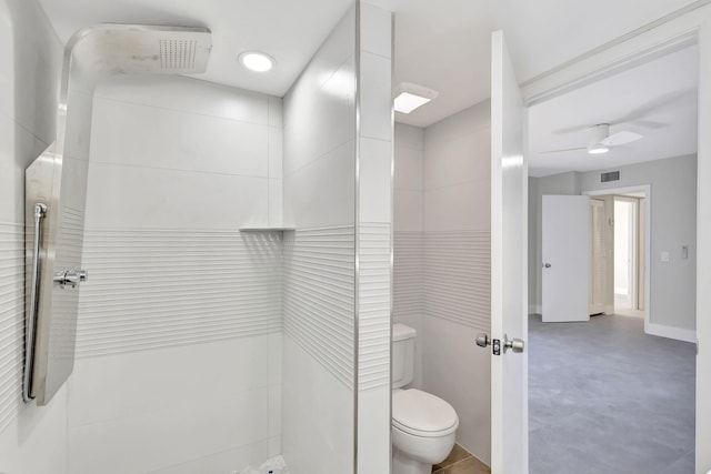 bathroom featuring a tile shower, concrete floors, toilet, and ceiling fan