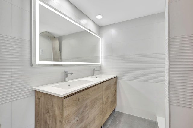 bathroom featuring vanity and tile walls