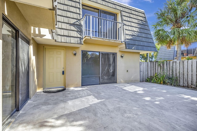 property entrance with a balcony and a patio