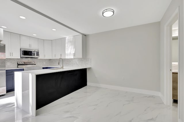 kitchen with sink, kitchen peninsula, appliances with stainless steel finishes, tasteful backsplash, and white cabinetry