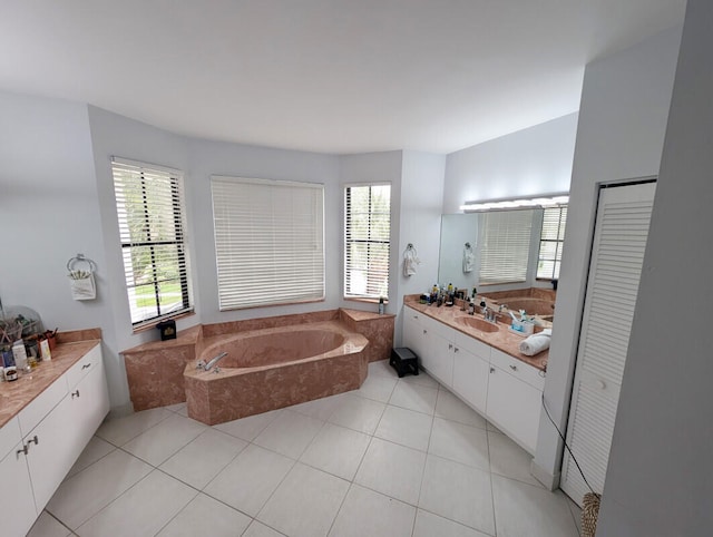 bathroom with tiled tub, tile patterned flooring, and vanity