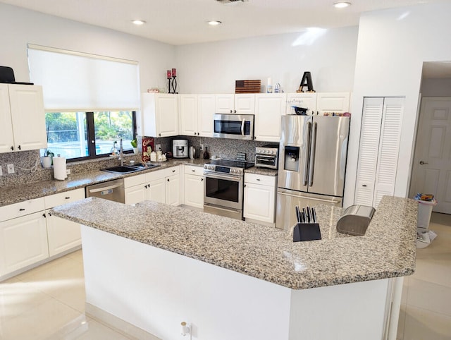 kitchen featuring light stone counters, sink, and stainless steel appliances