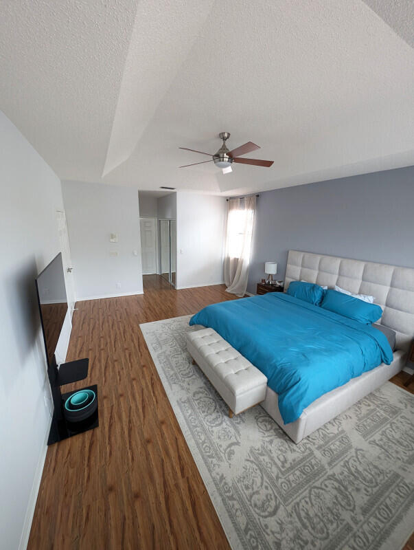 bedroom featuring ceiling fan, a textured ceiling, and hardwood / wood-style flooring