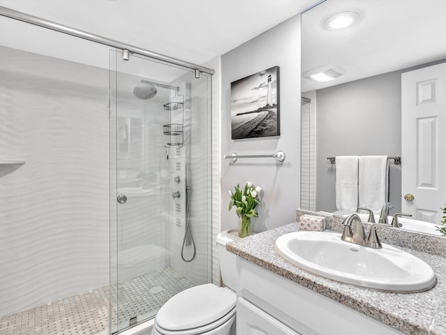 bathroom with vanity, toilet, and a shower with shower door